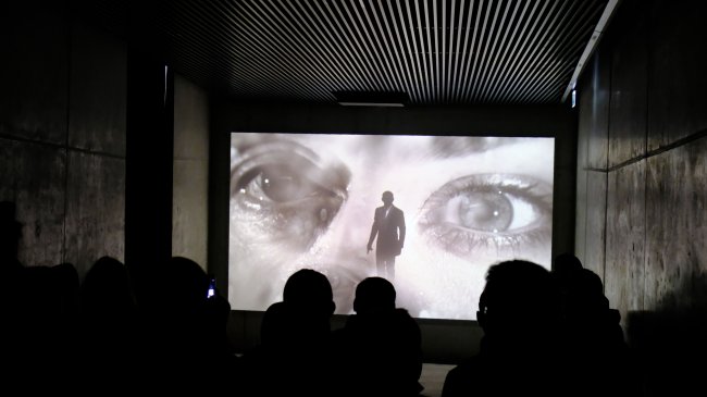 Огляд починається з гостьового холу, де режисер Сем Мендес з величезних екранів розповідає історію Бондіани - від Доктора Ноу до Спектра